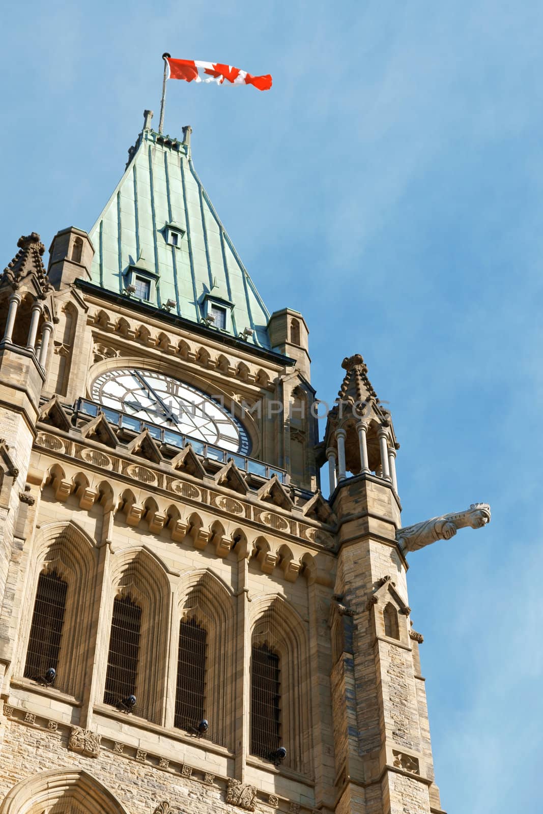 Detail of the tower of the Parliament of Canada in Ottawa with national flag