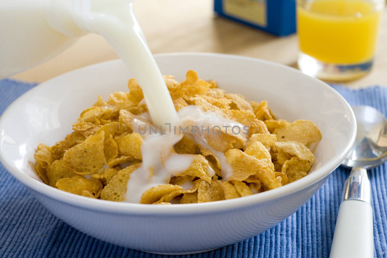 milk being poured into a bowl of cereal