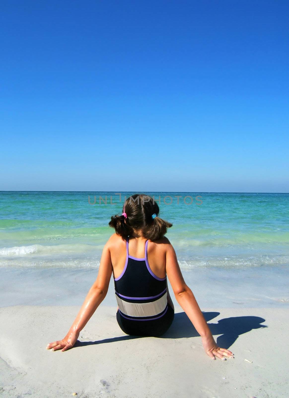 a girl sitting on the beach enjoying the sun by gemphotography