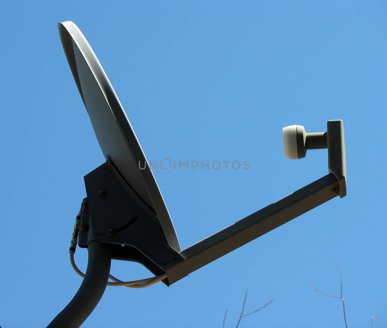 Satellite dish isolated against a clear blue sky.