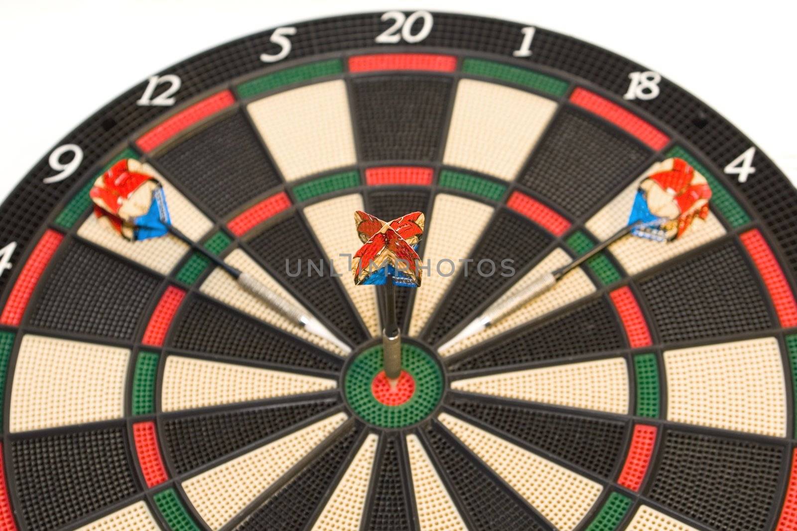 Darts hitting the bullseye on a dartboard