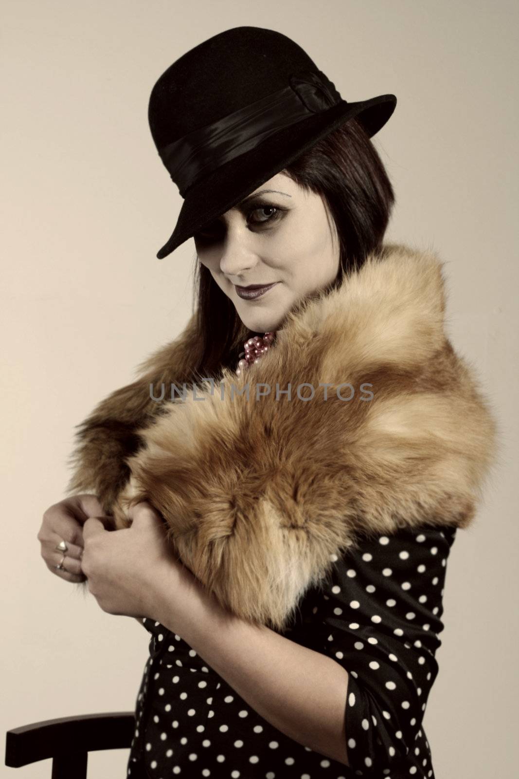 Retro styled fashion portrait of a young woman. Clothing and make-up in twenties style.