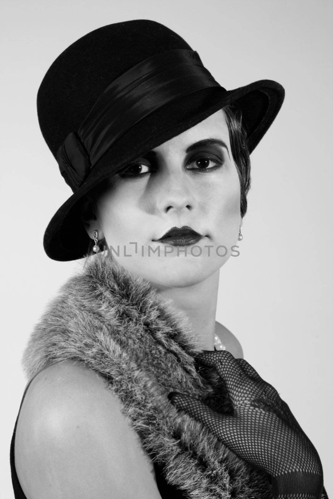 Retro styled fashion portrait of a young woman. Clothing and make-up in twenties style.