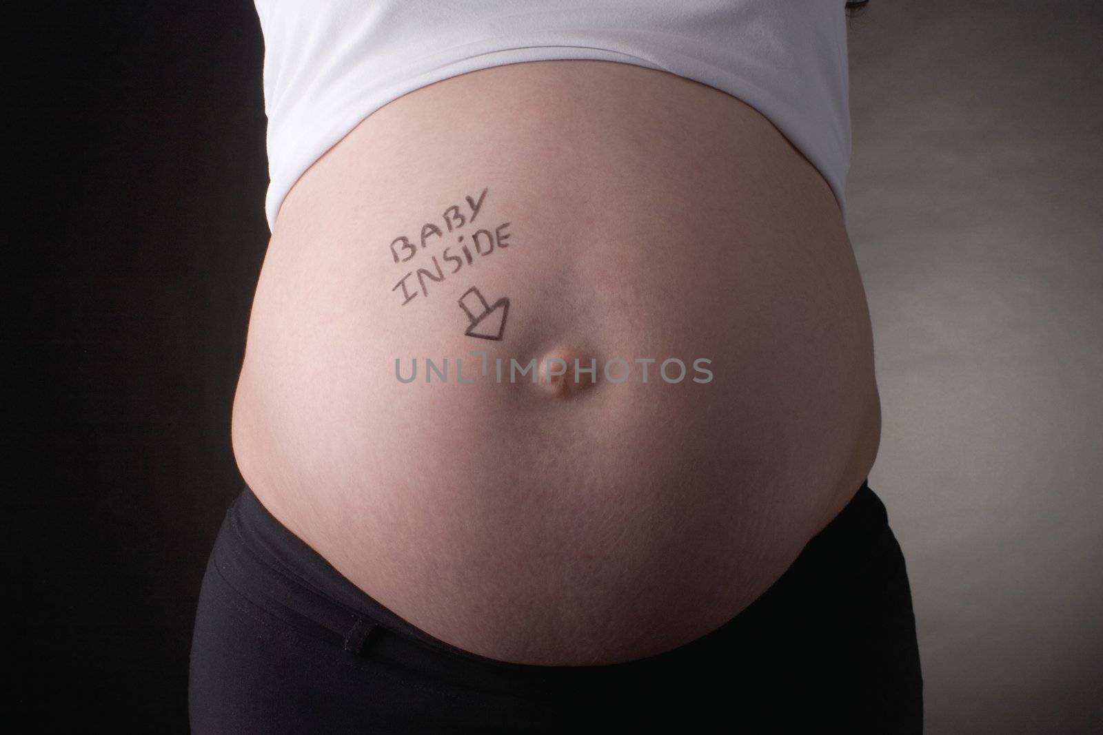 seven month pregnant belly with baby inside writting 