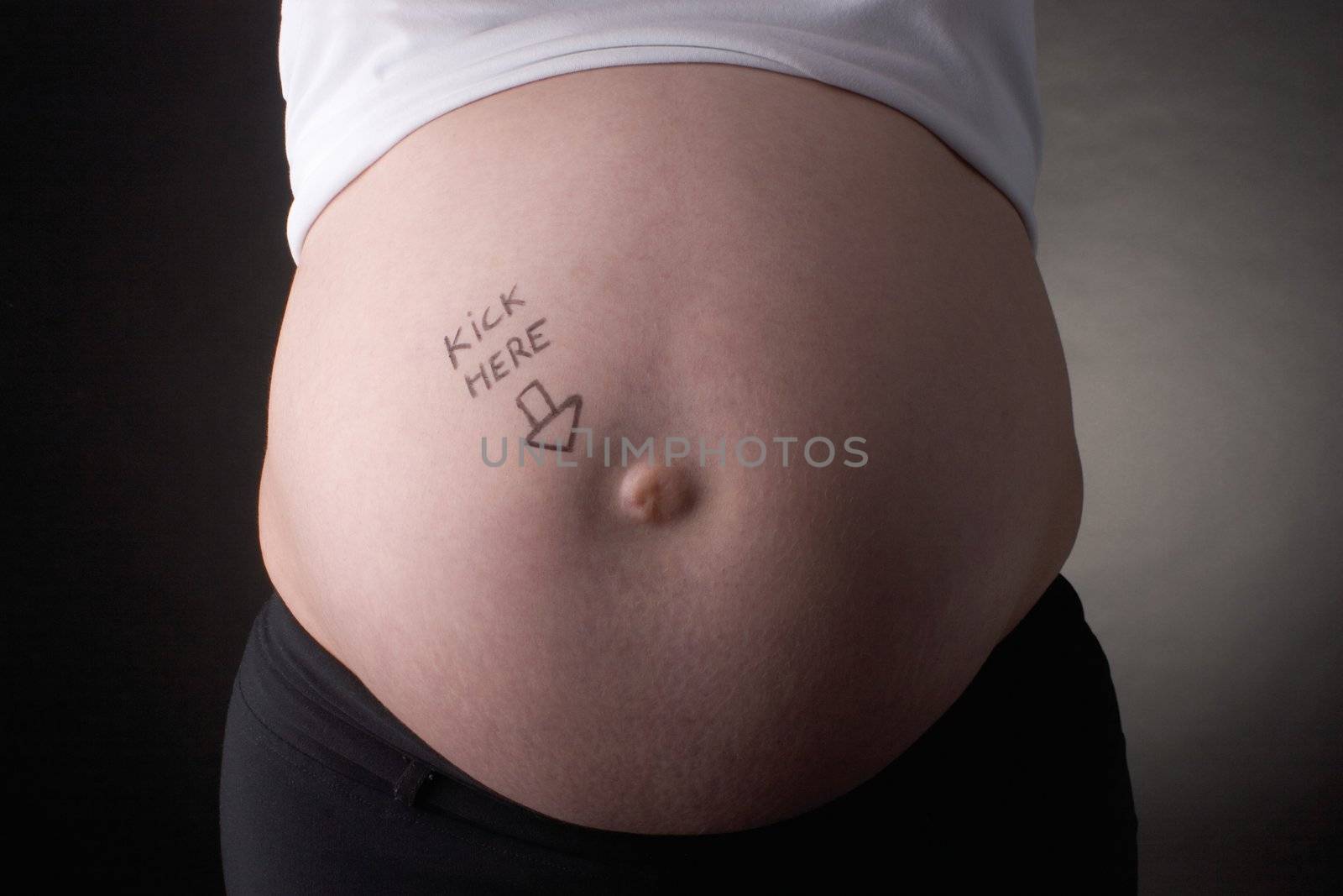 seven month pregnant belly with kick here arrow