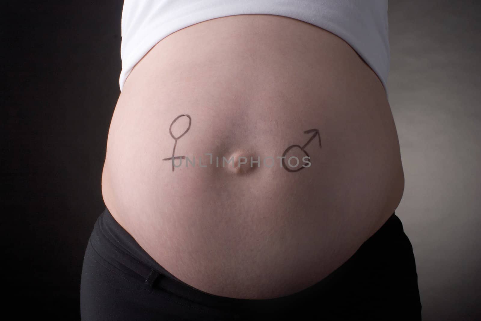 seven month pregnant belly with male and female sign drawn on the stomach