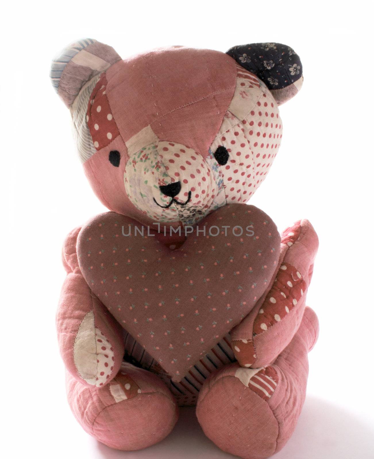 teddy bear made from antique quilts holding a large mauve calico heart
