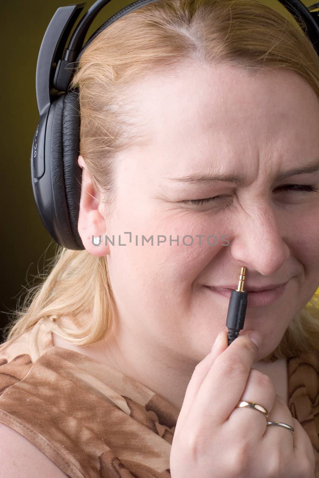 Women trying to plugin headset in her nose with any success