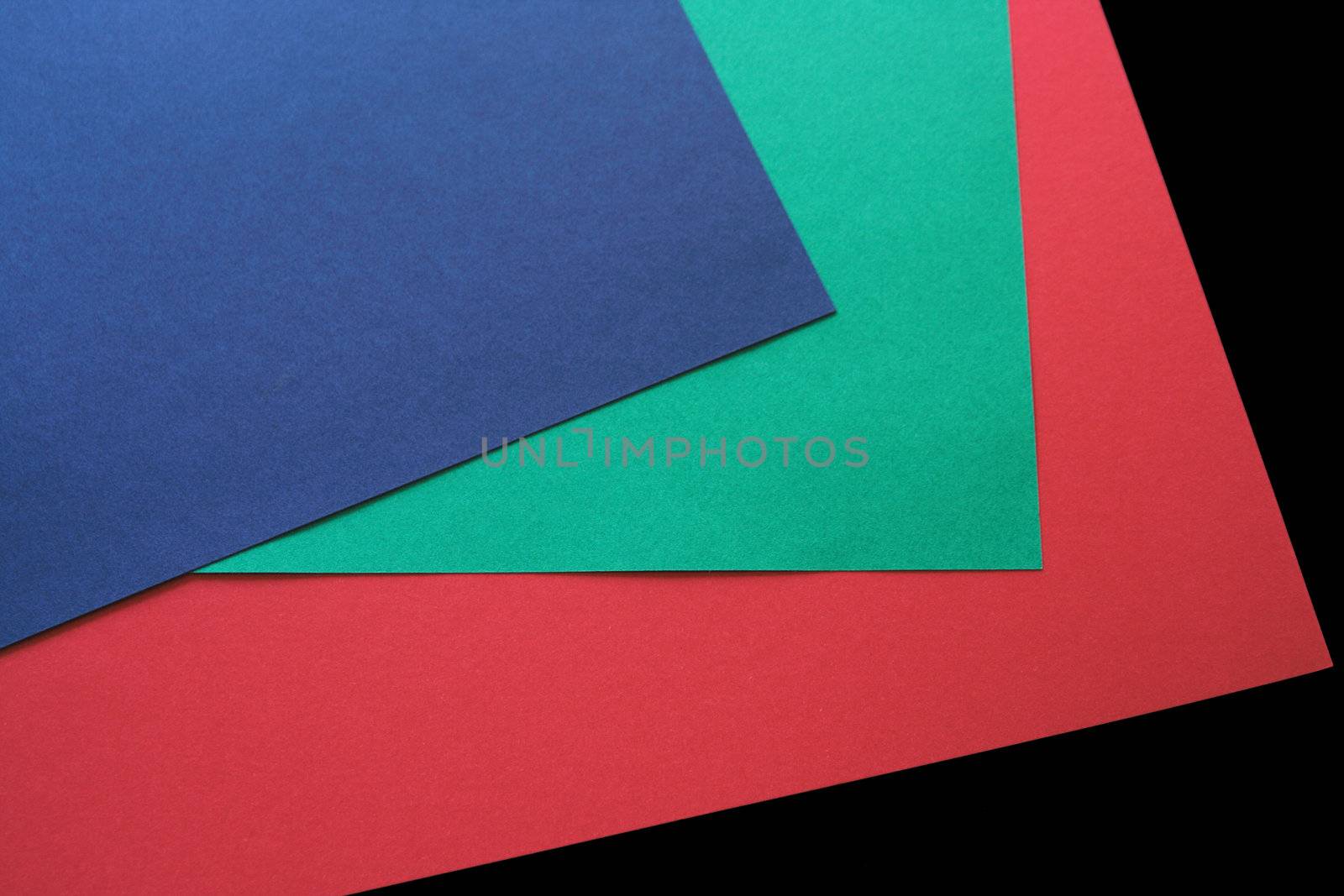 red, green and blue paper on a black background