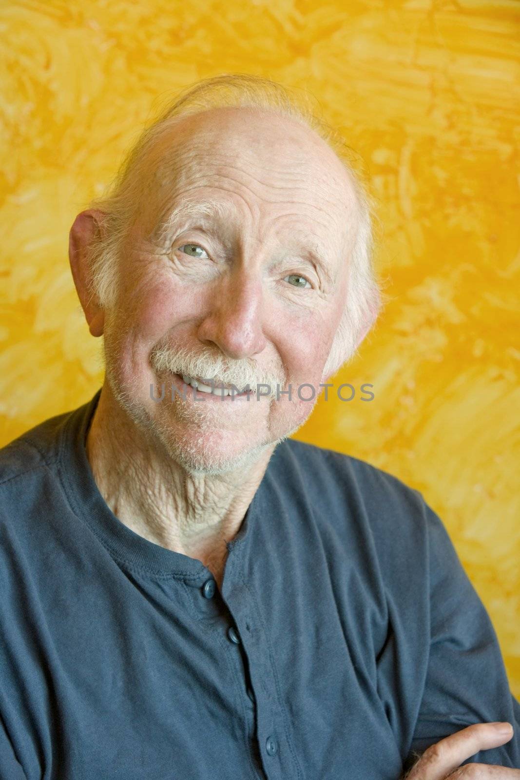 Portrait of an elderly man against a yellow background
