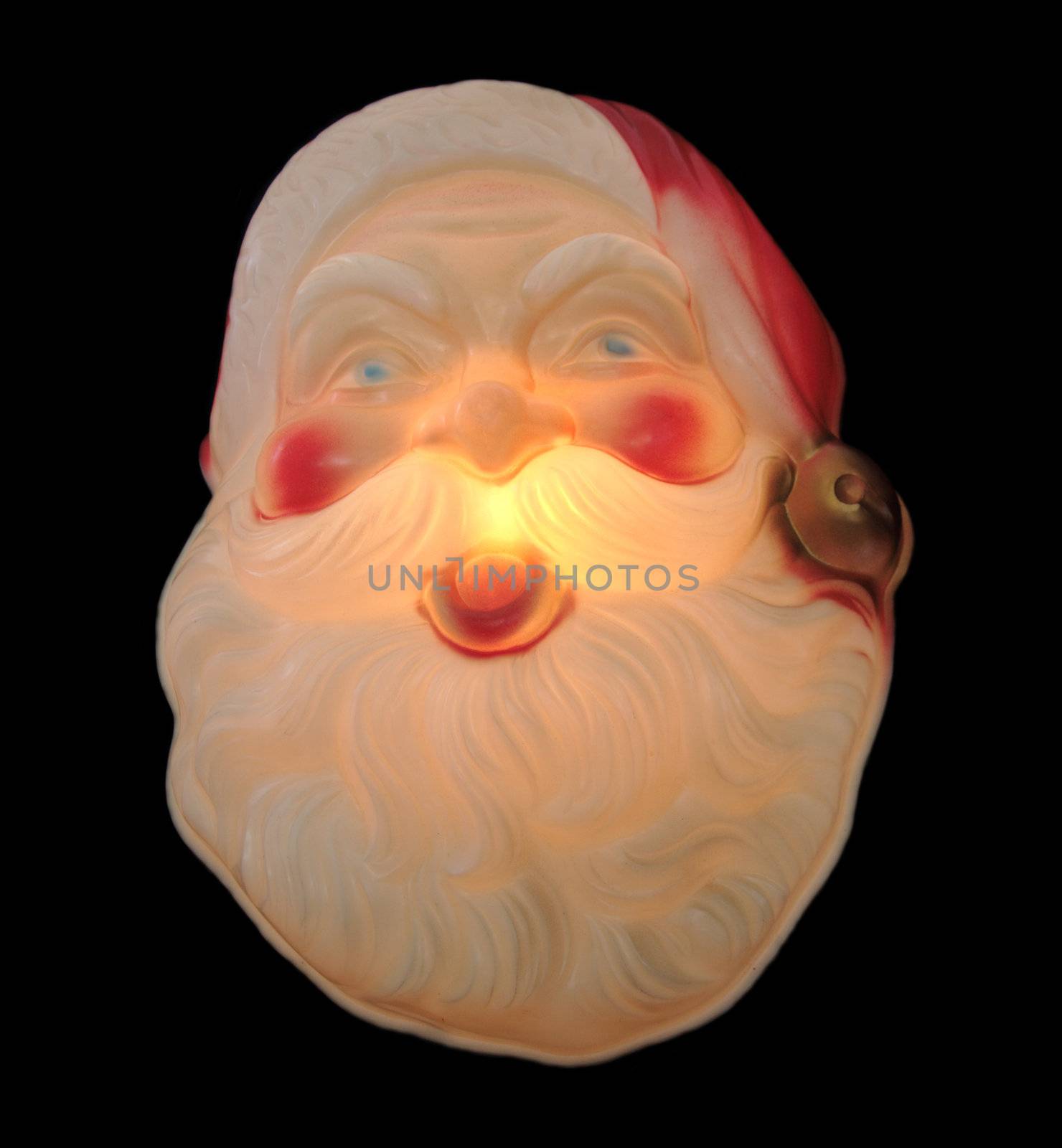 old Santa Claus decoration lit up and isolated on black