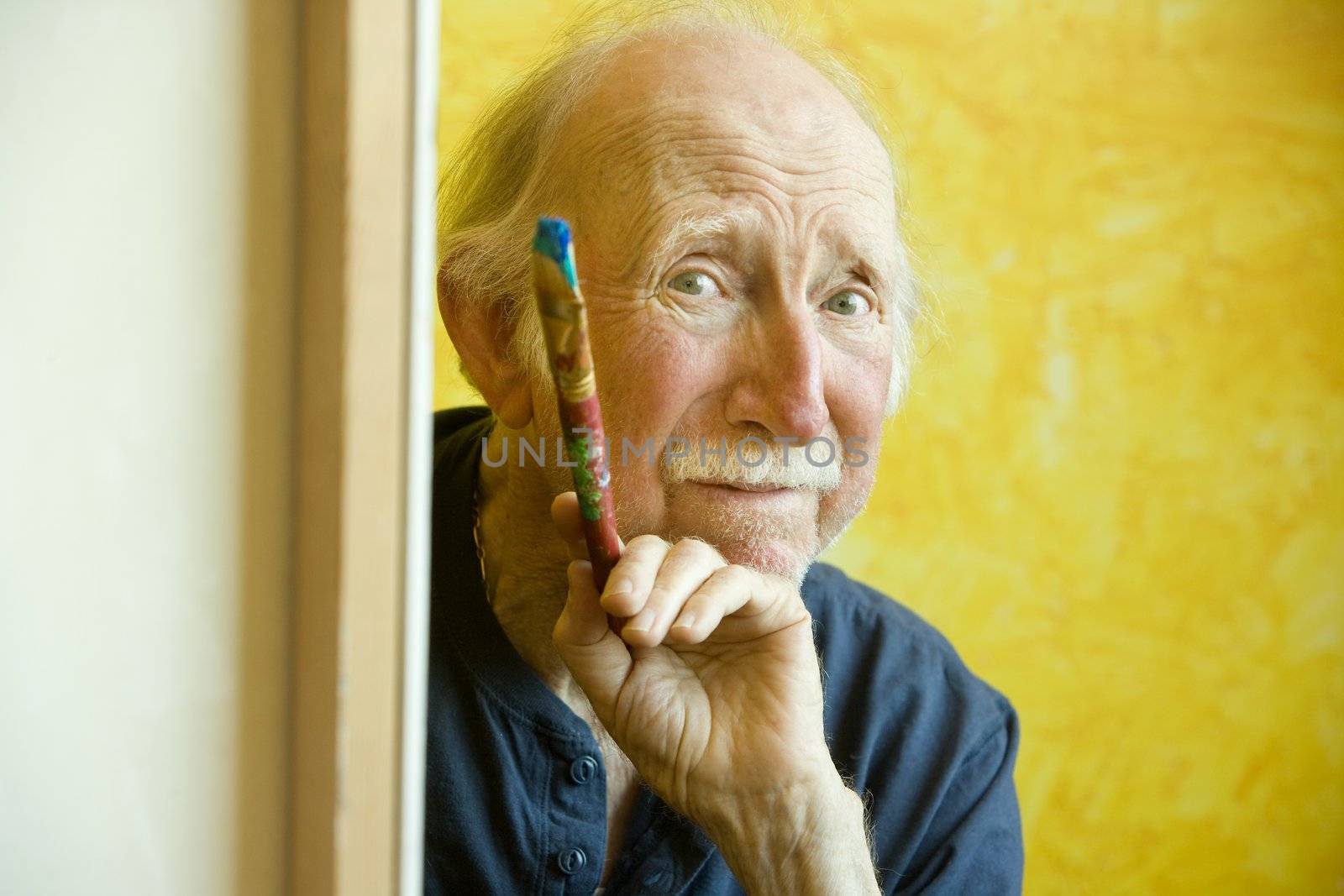 Elderly painter working on a large canvas
