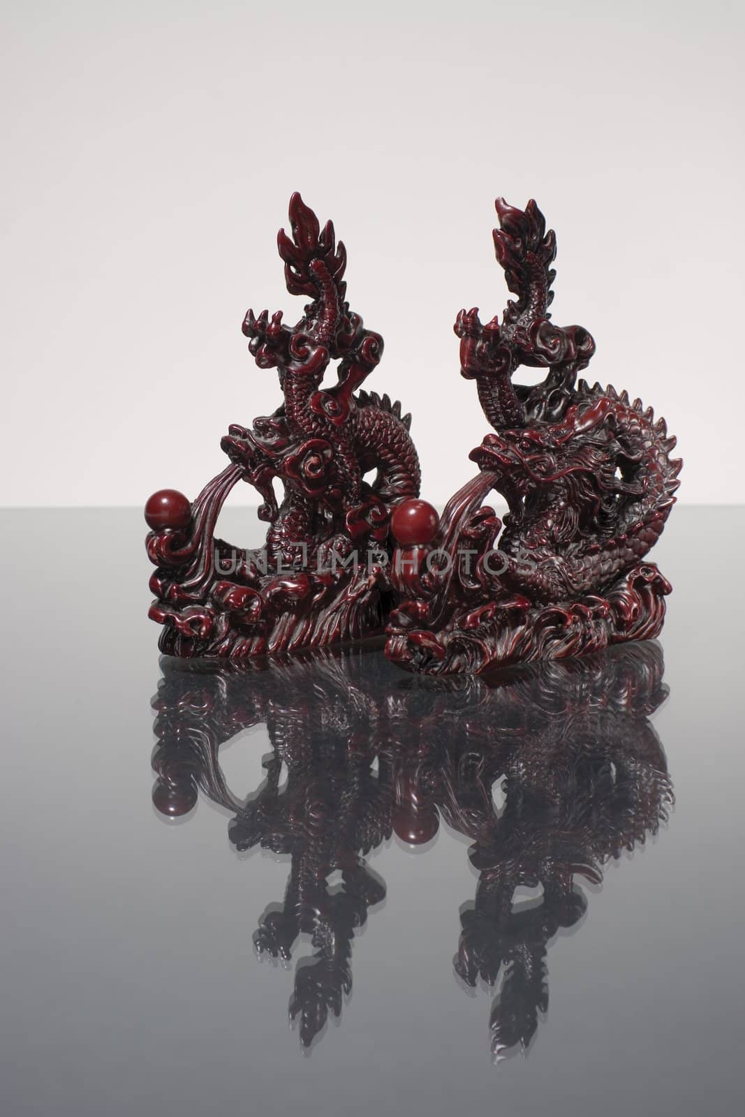 Twow dragon statue racing over reflecting surface