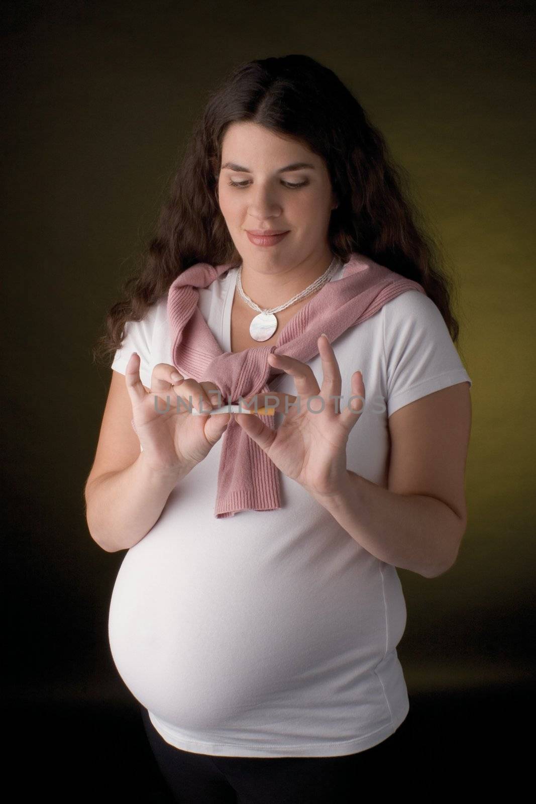 Seven month pregnant women holding a cigarette in her hand