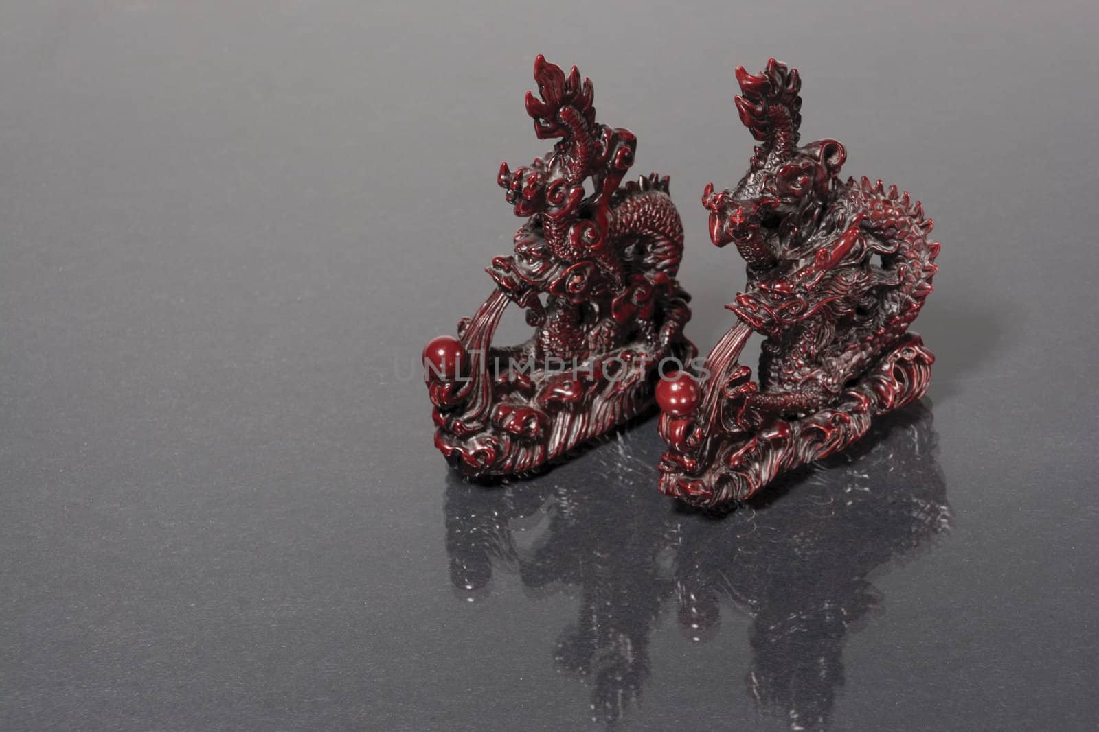 two dragon statue racing on a gray reflective surface
