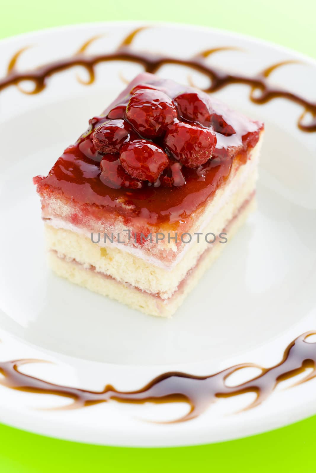 Piece of raspberry cake on the plate with chocolate dressing