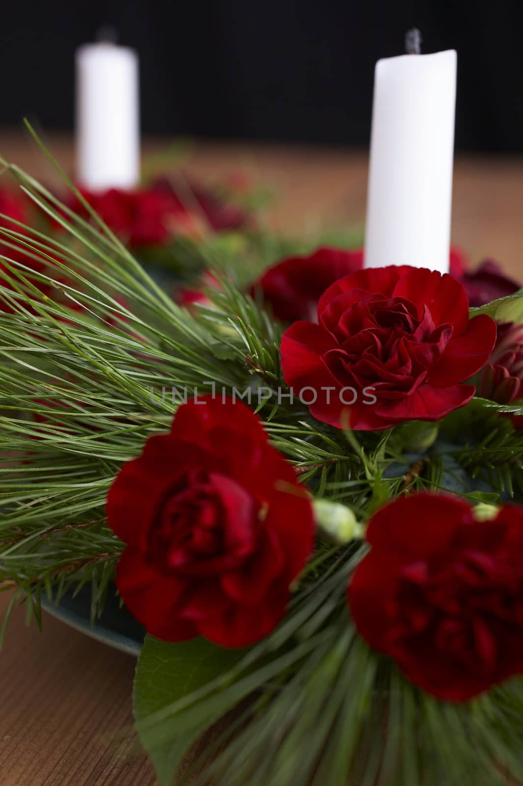 Candles with flower setup on the brown table over black background