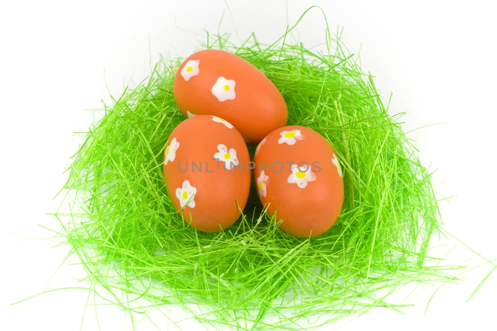 Three red easter eggs with green grass isolated on white