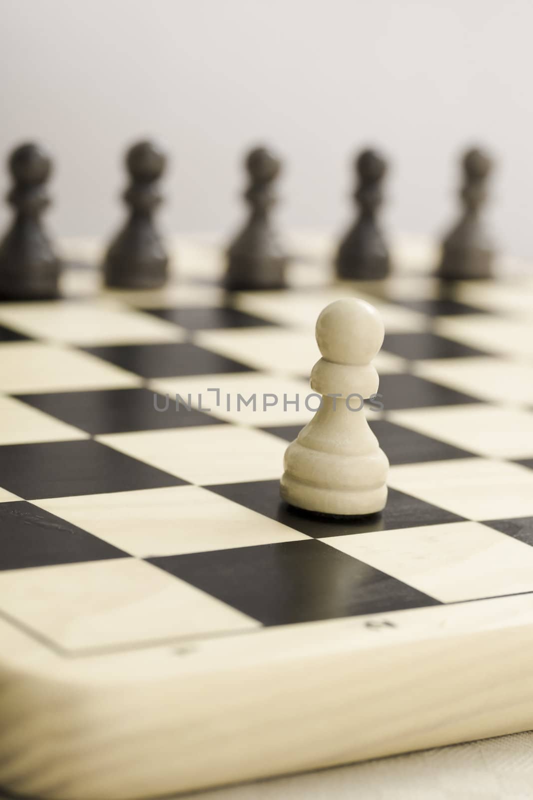 One white soldier against black on chess board.