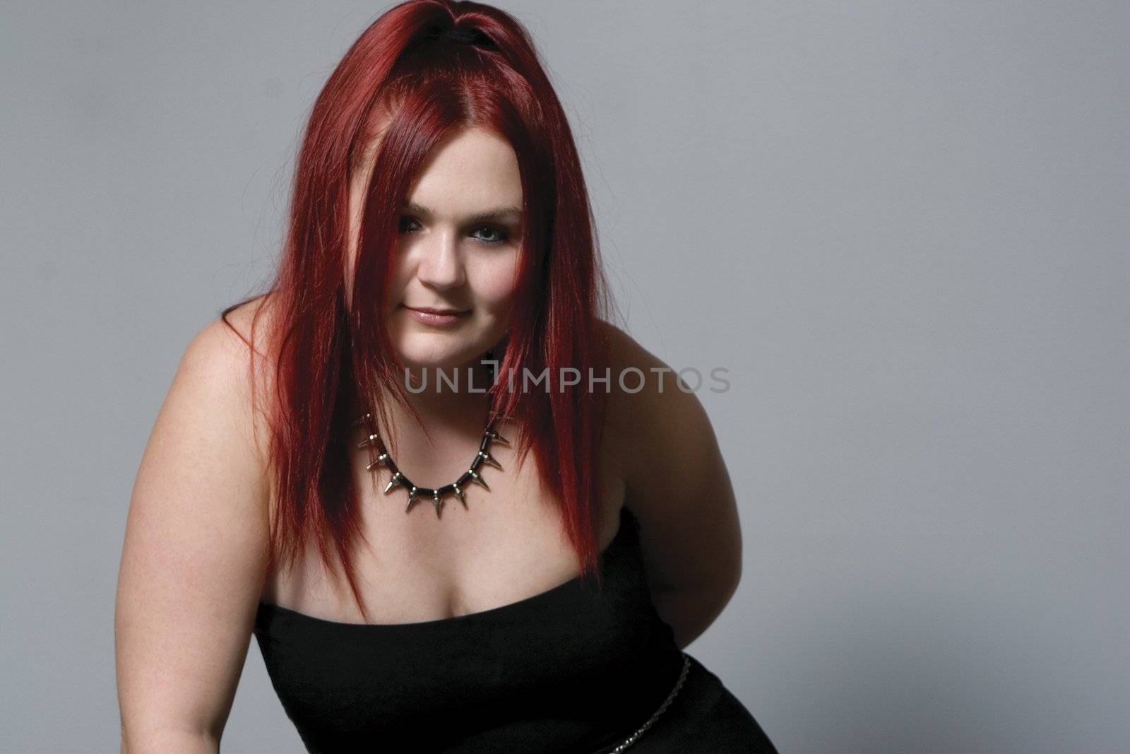 Red hair female model in suggestive position and goth look