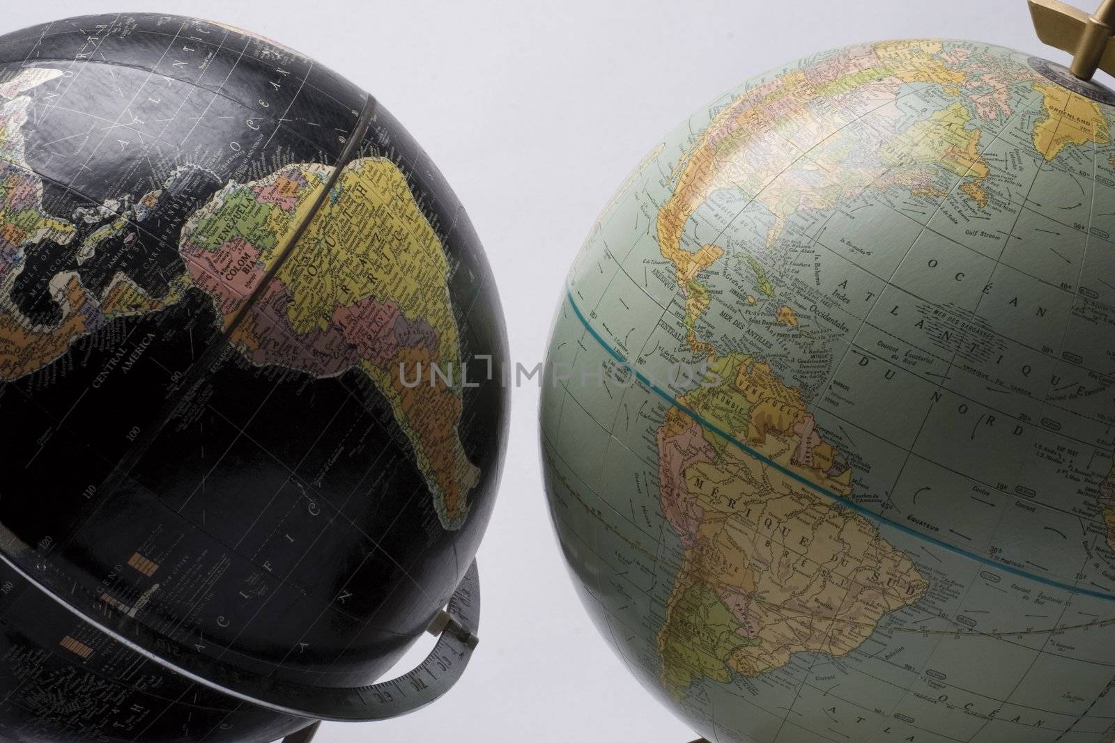 A dark globe facing a light globe showing america