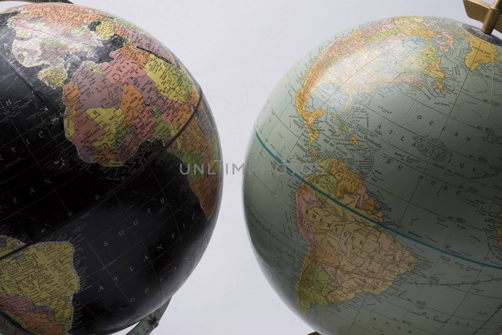 A dark globe showing africa facing a light globe also showing south america
