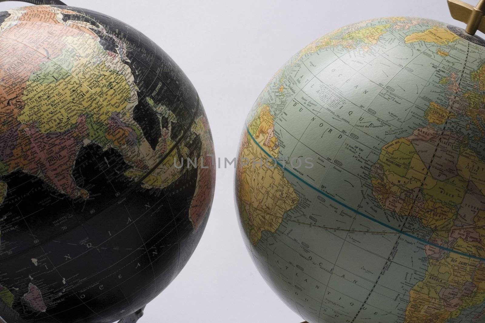 A dark globe showing asia facing a light globe showing america