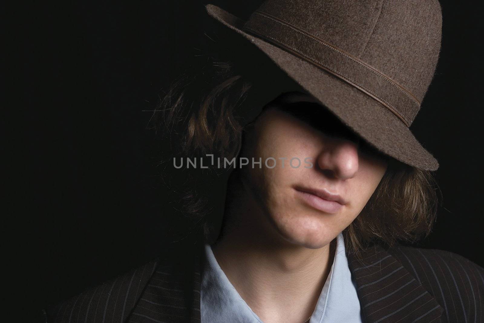 Young man faces partly hidden by hat