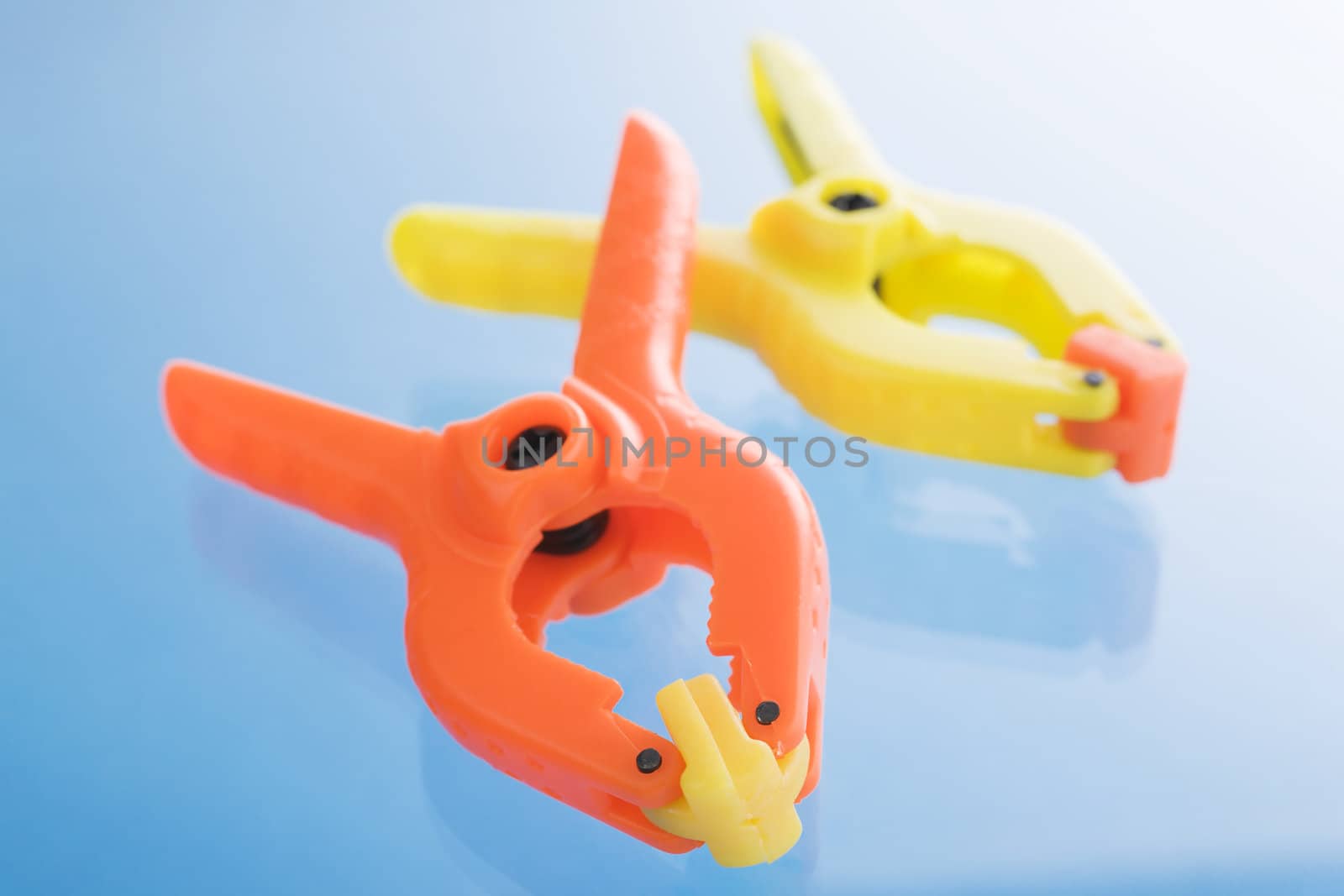 Plastic clamps over a blue reflective background