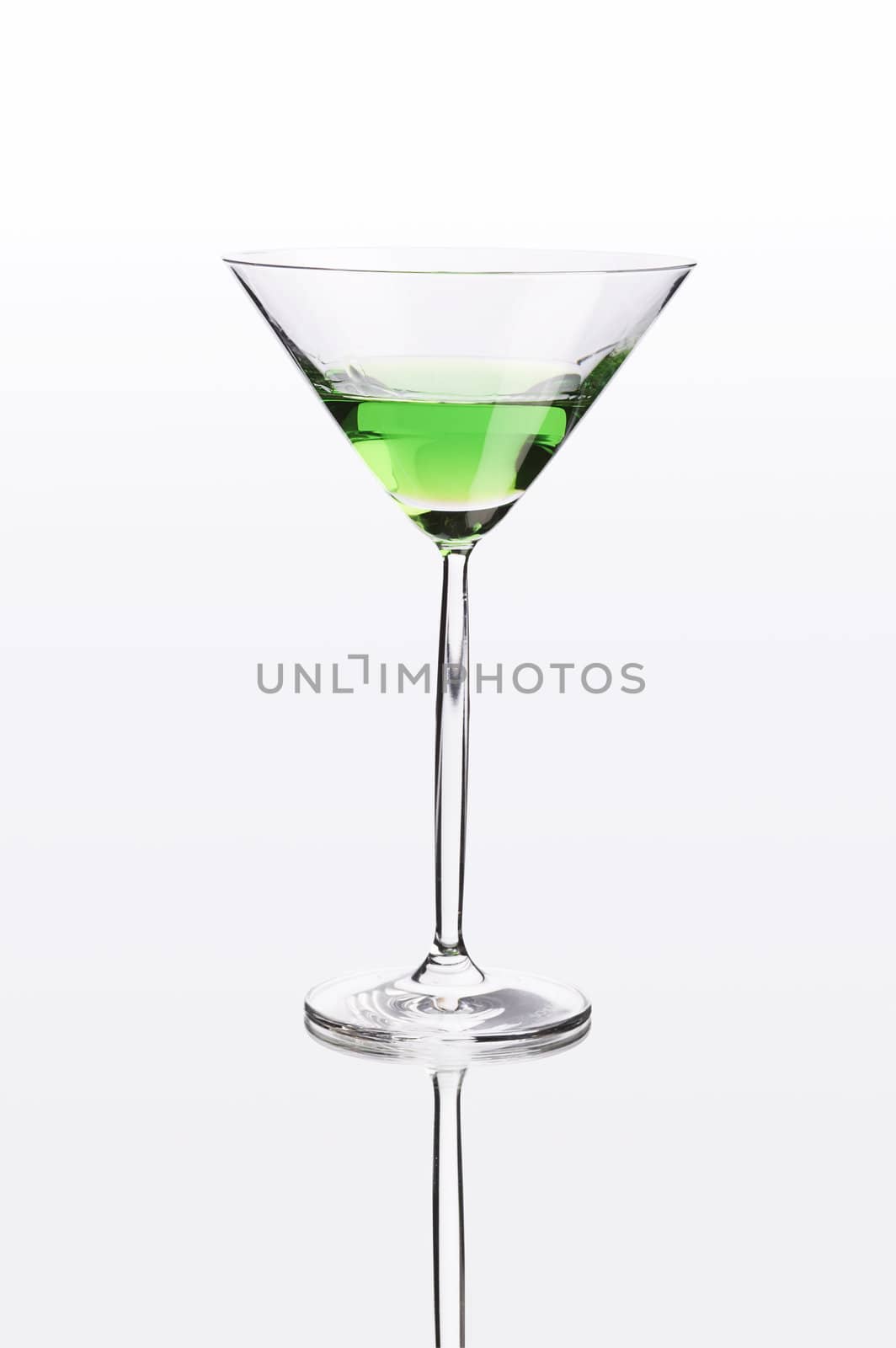 Green cocktail on white mirror like surface with clipping path