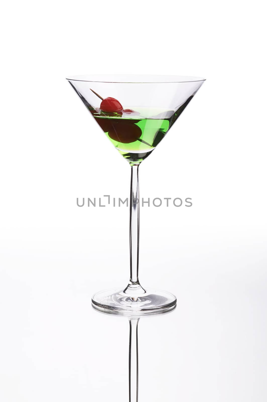 Green cocktail on white mirror like surface with clipping path