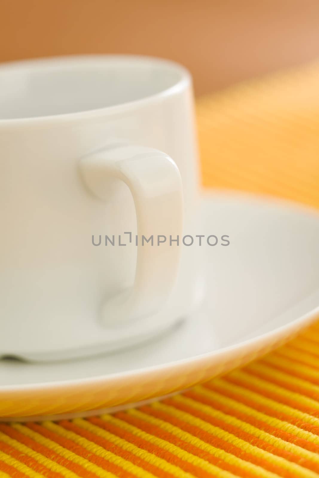 Empty coffee on orange - yellow striped fabric 