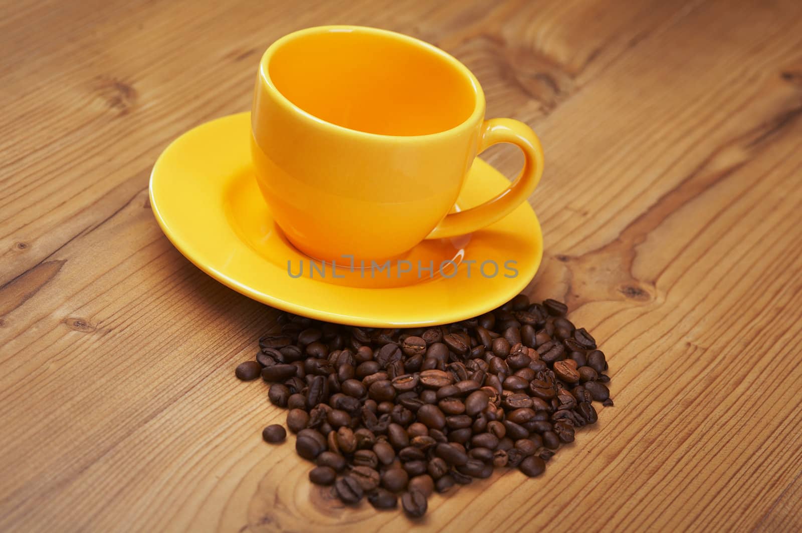 Empty yellow coffee cup on a wooden kitchen table 