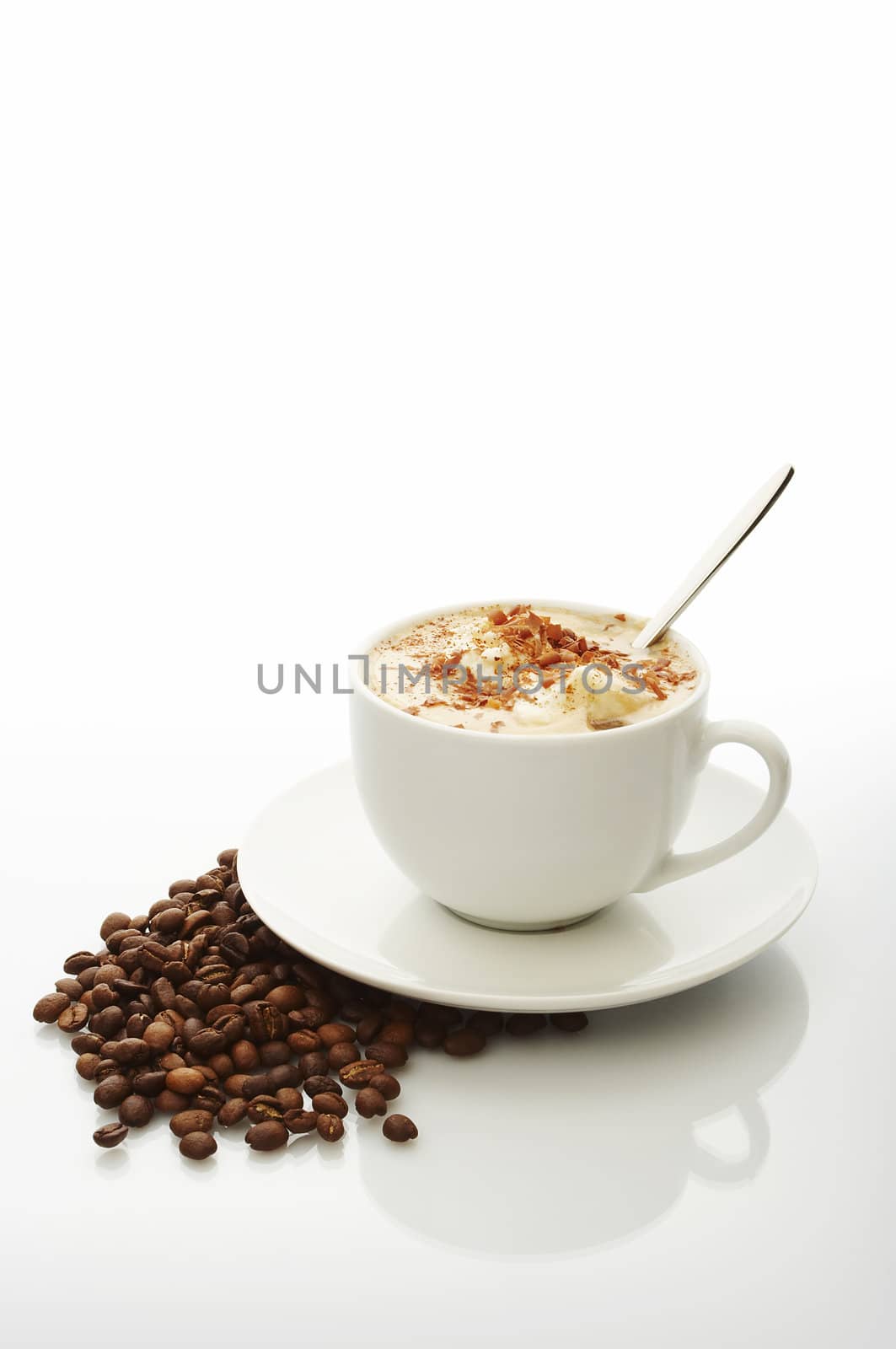 White cup of cappuccino with coffee beans