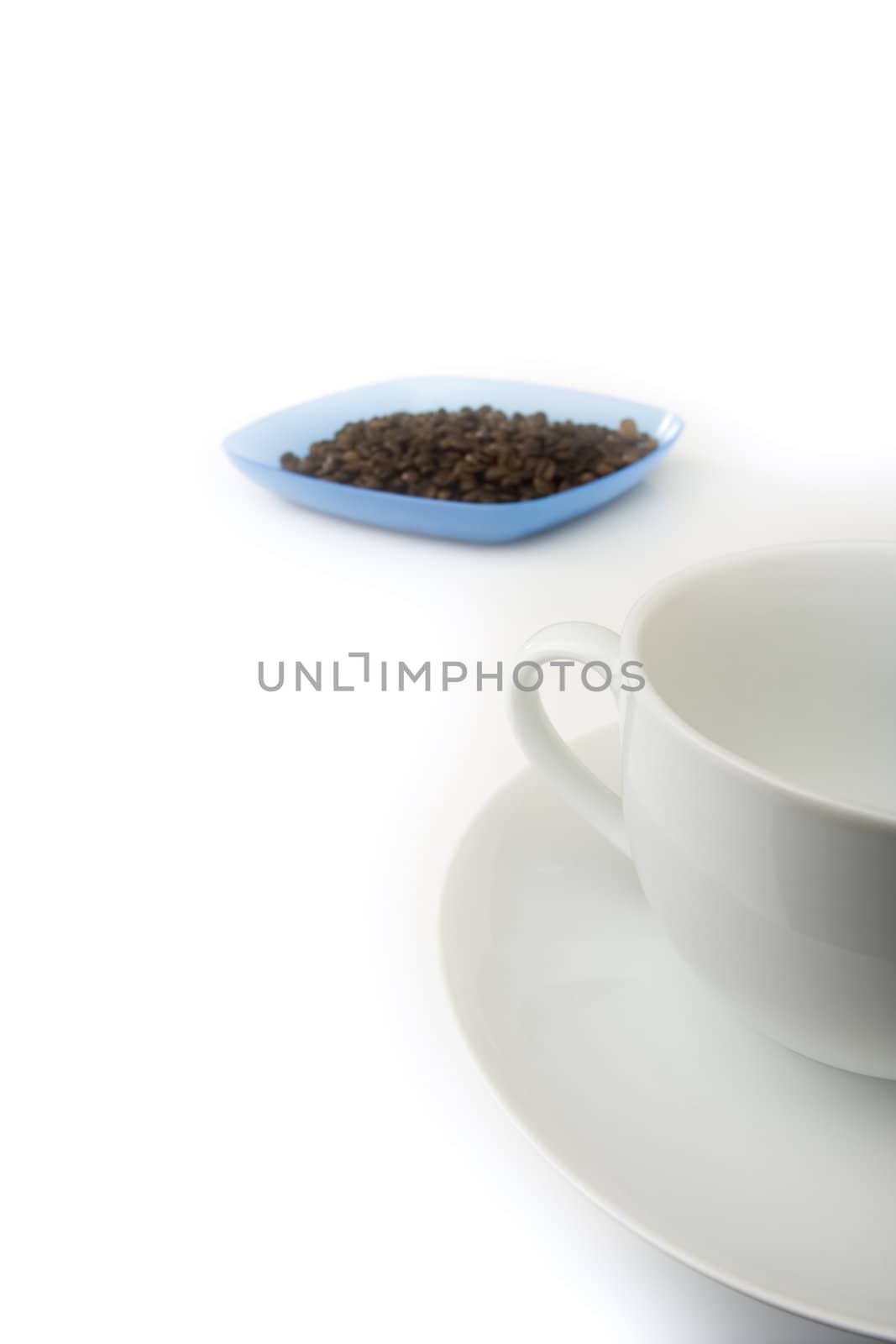 White empty coffee cup with plate full of beans