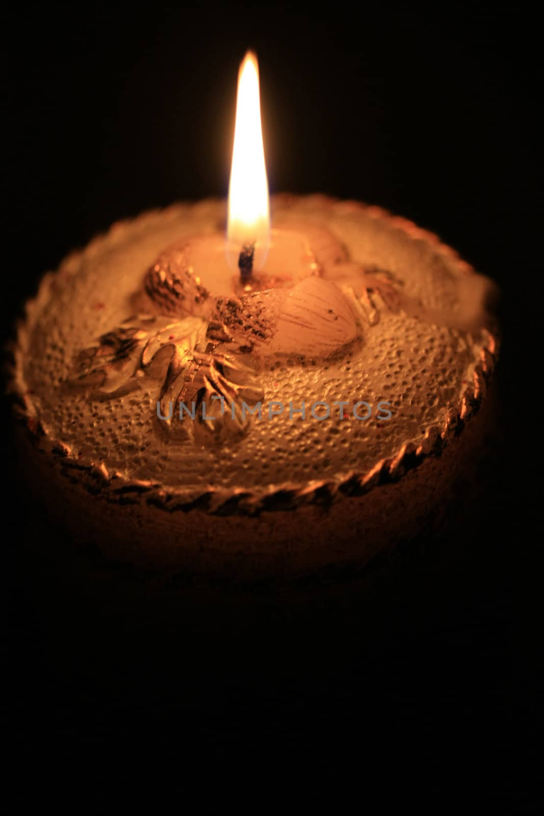 A detail of a burning decorated christmas candle