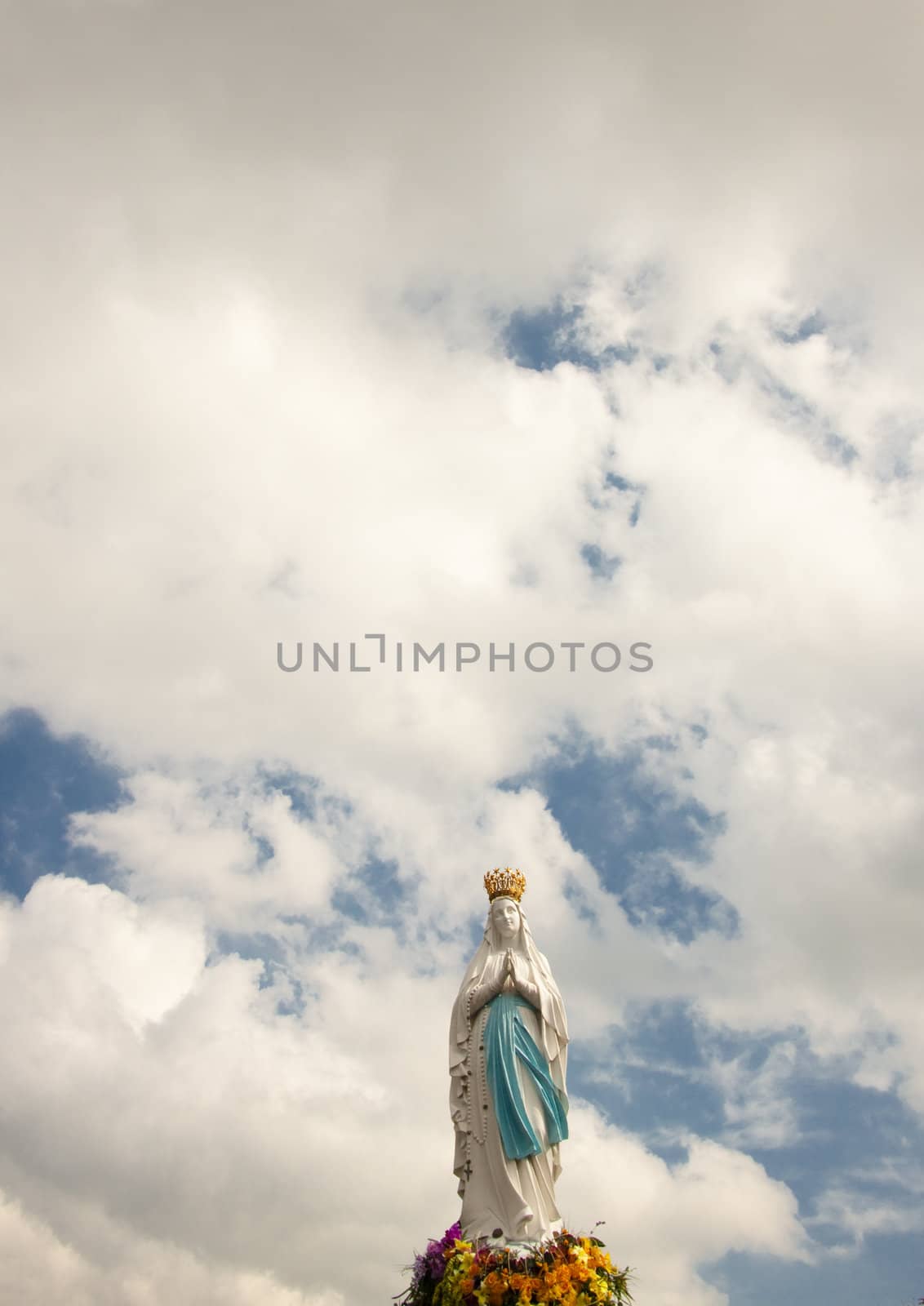Clouds on the sky and Big figure of the Madonna in Lourdes - France.