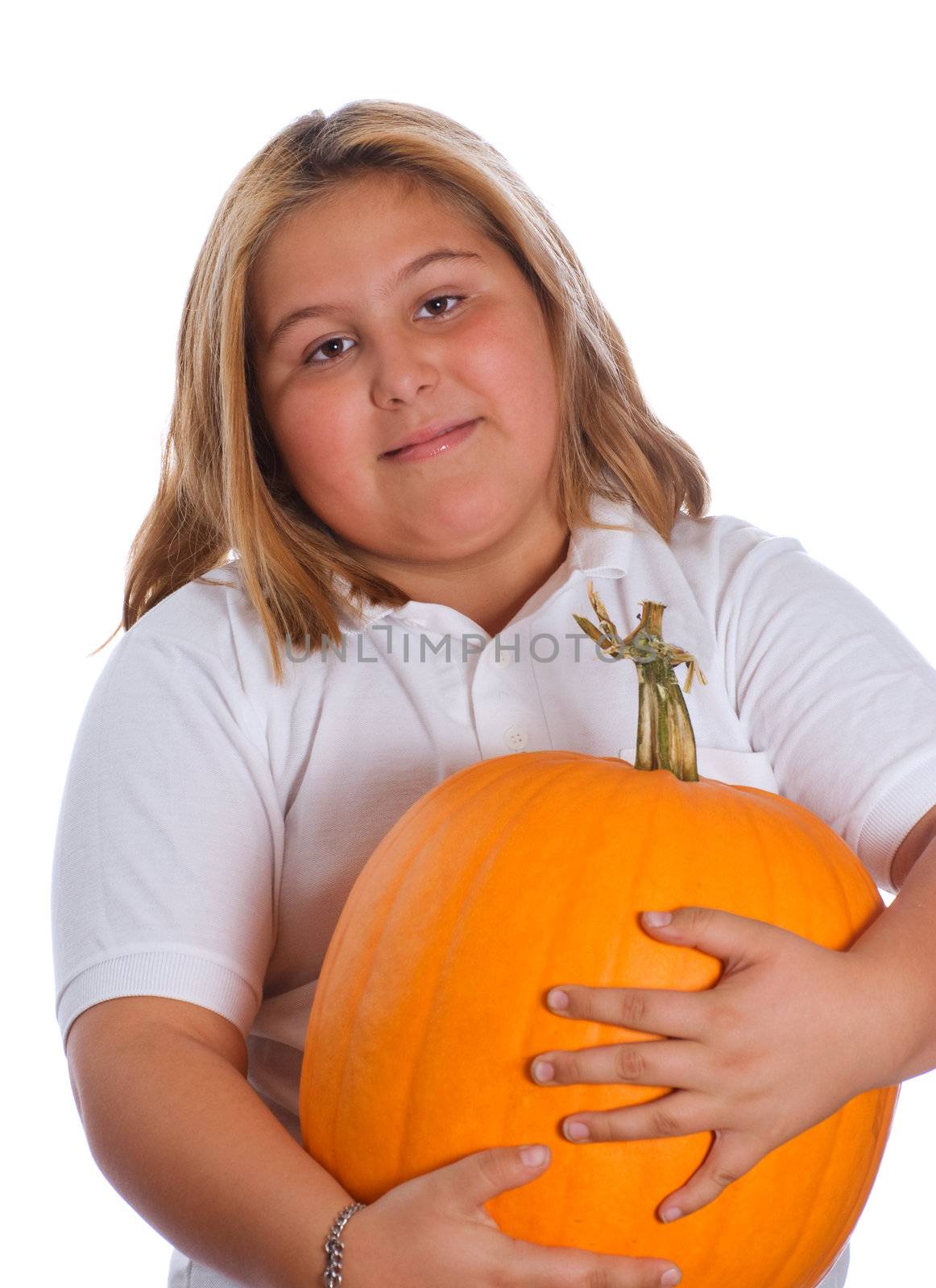 A young girl holding a heavy and large pumpkin, isolated against a white background