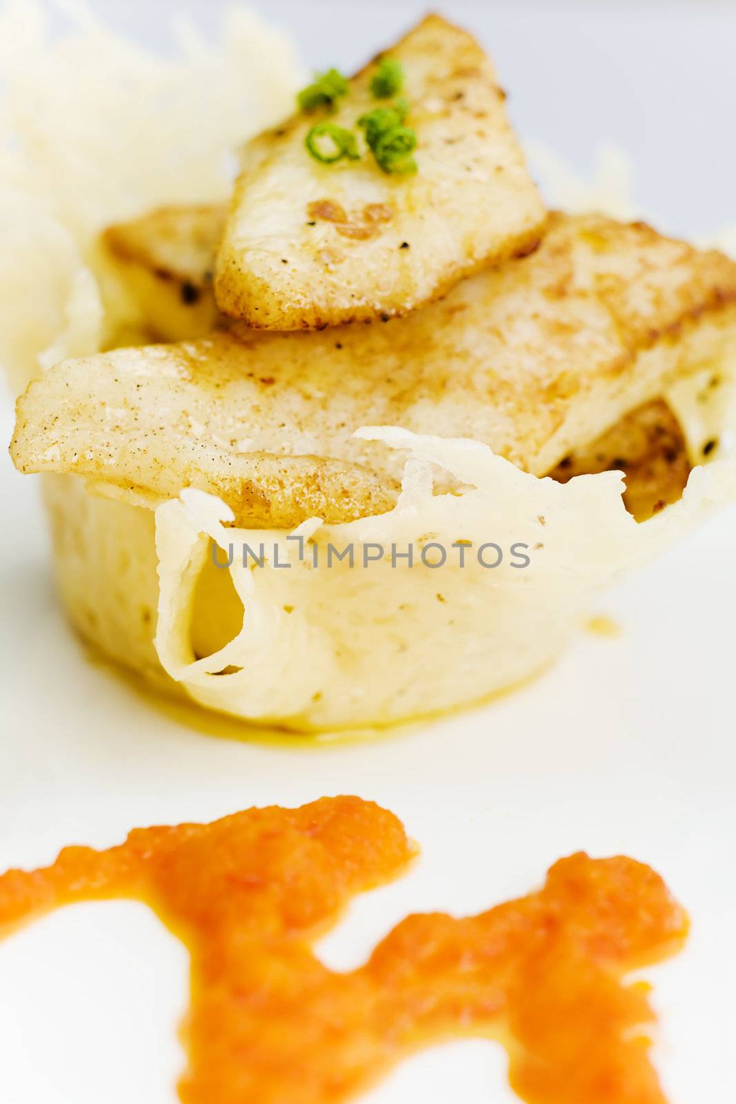 White fish on the cheese basket with pepper dressing