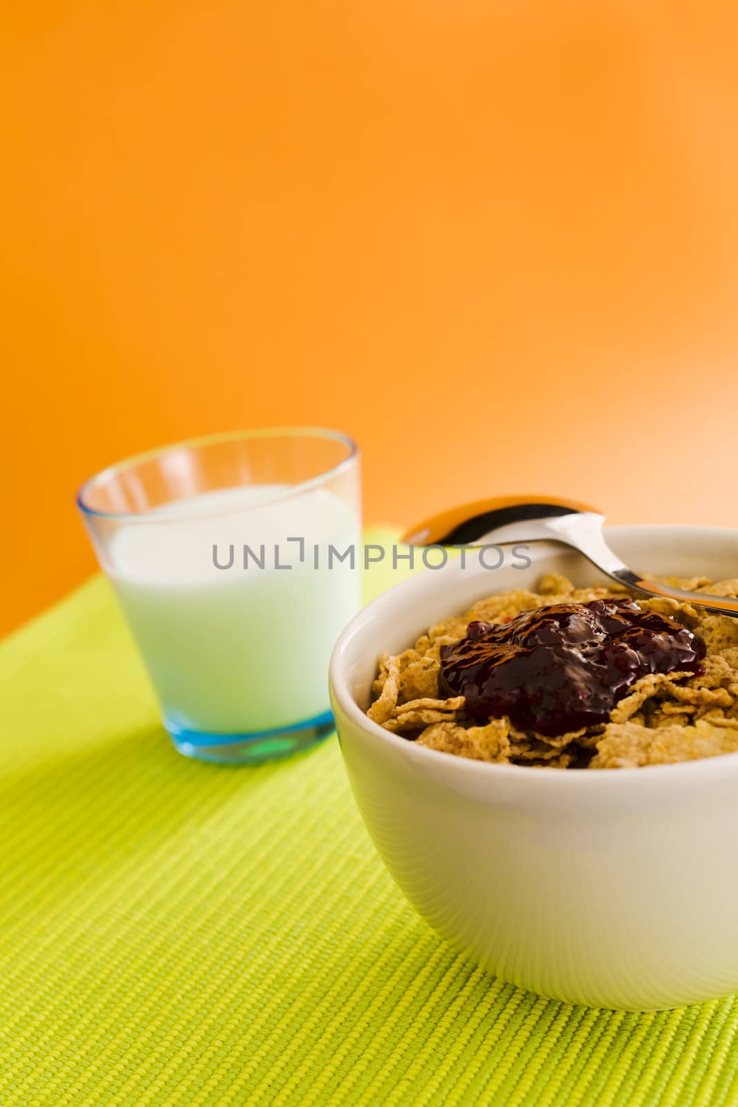 Corn flakes on the vase with jam and spoon