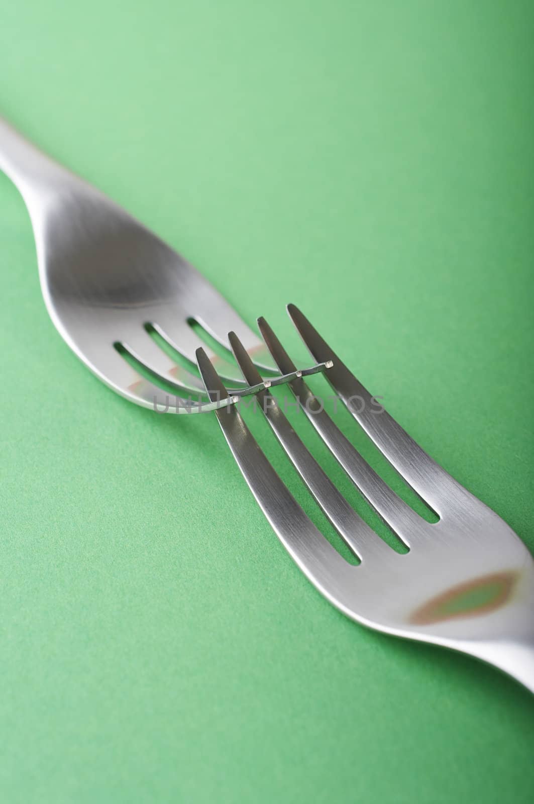 Two forks crossed on the green table