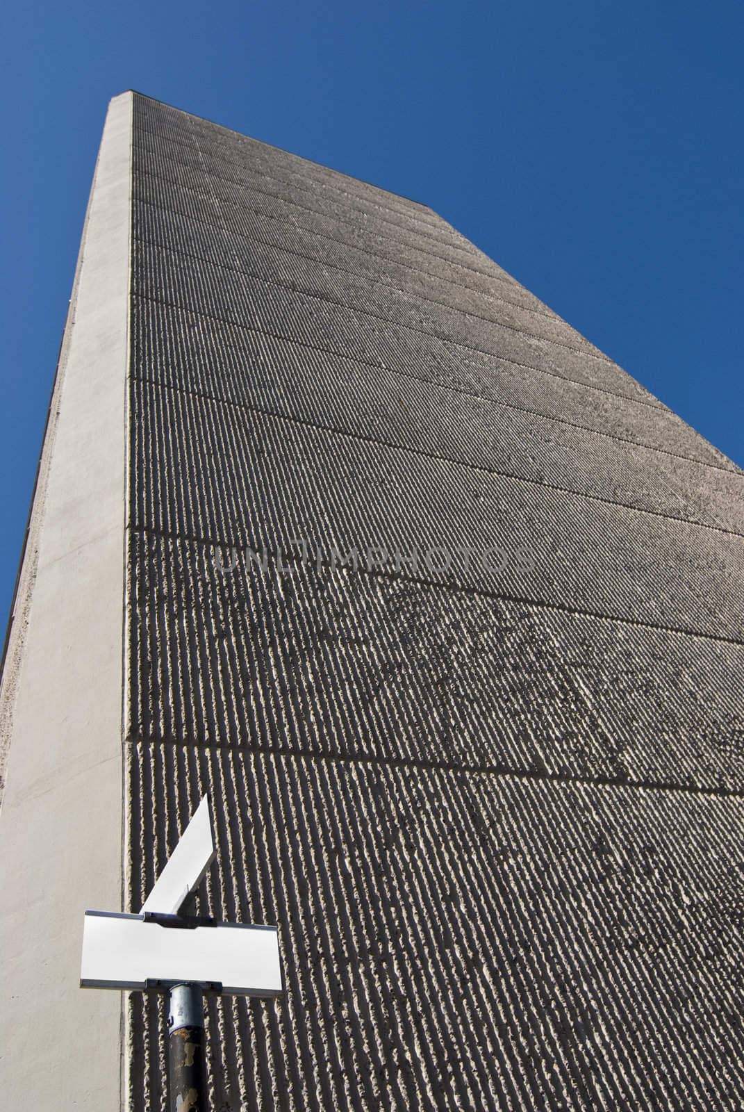 Huge concrete building with blank crossing signs in front of it