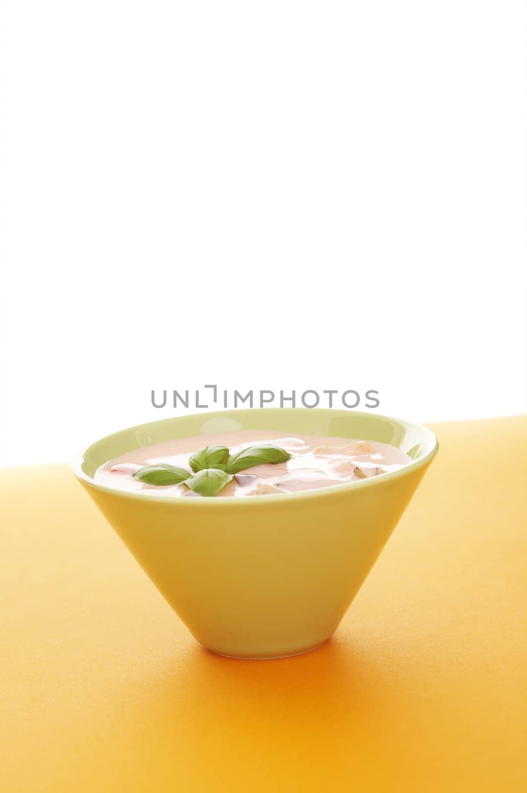 Fruits with yoghurt  over a orange background (lots of copy space)