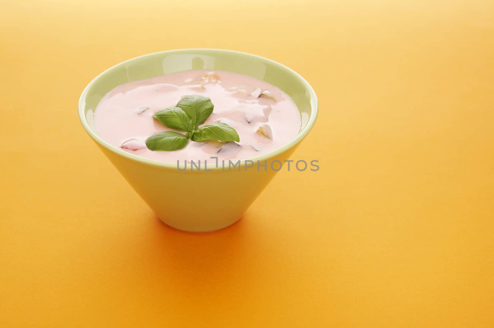 Fruits yoghurt in a bowl over a orange background