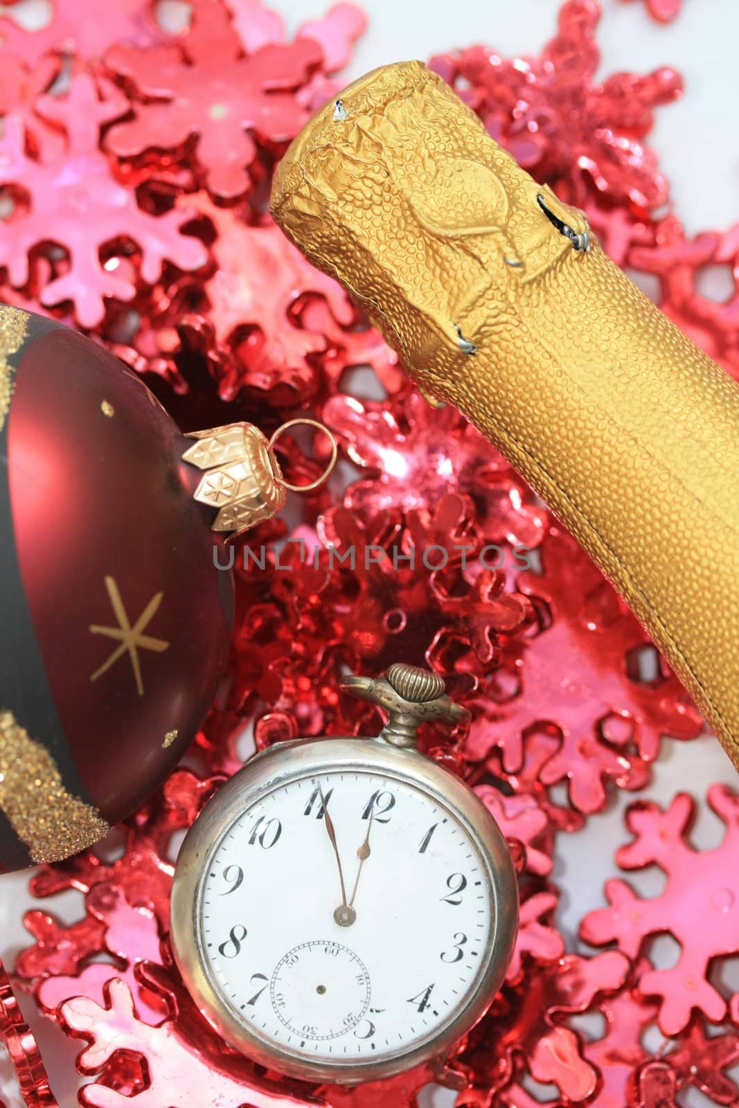 Champagne bottle, christmas ball and a vintage pocket watch