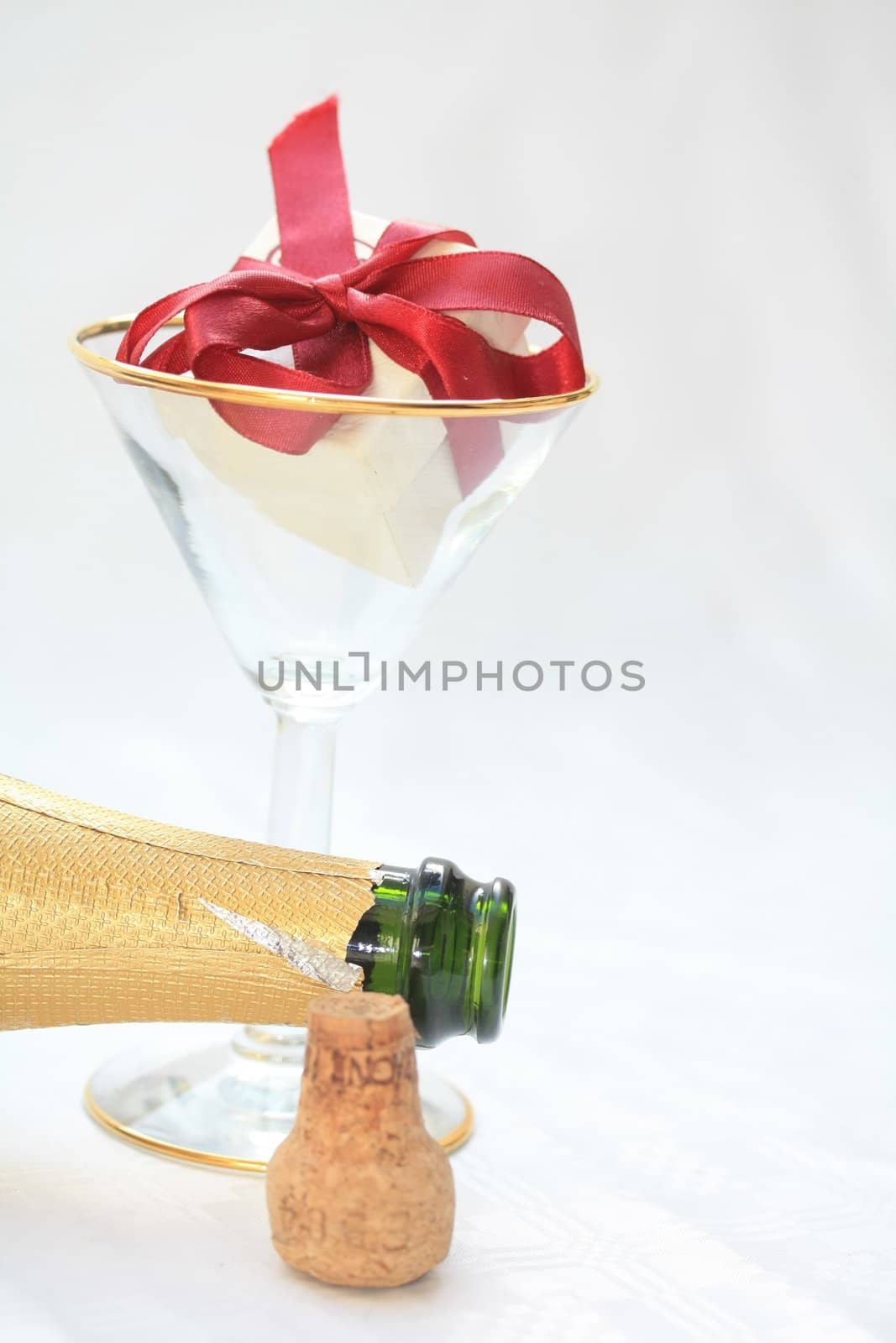 Open bottle of champagne and a ringbox in a champagne glass, a champagne proposal