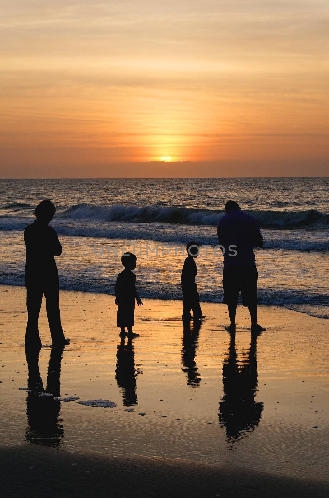 A family at the ocean at sunrise.
