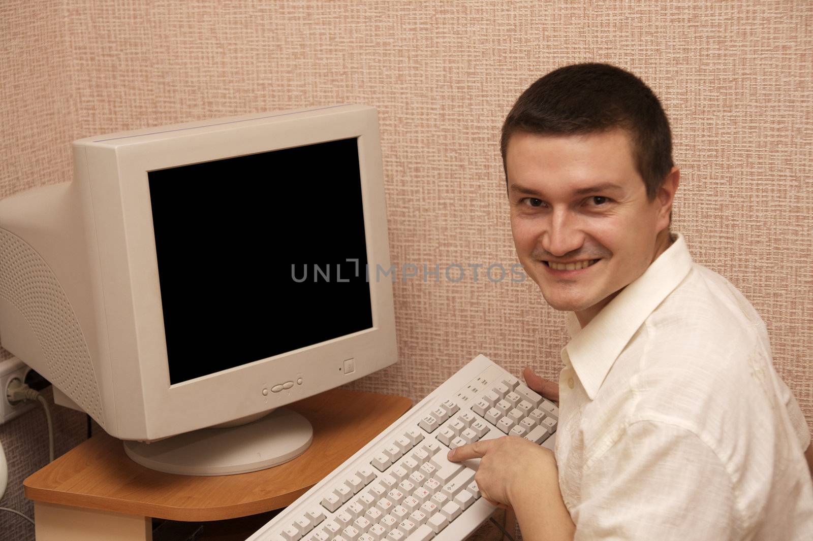 smiling businessman press a key by alkorphoto