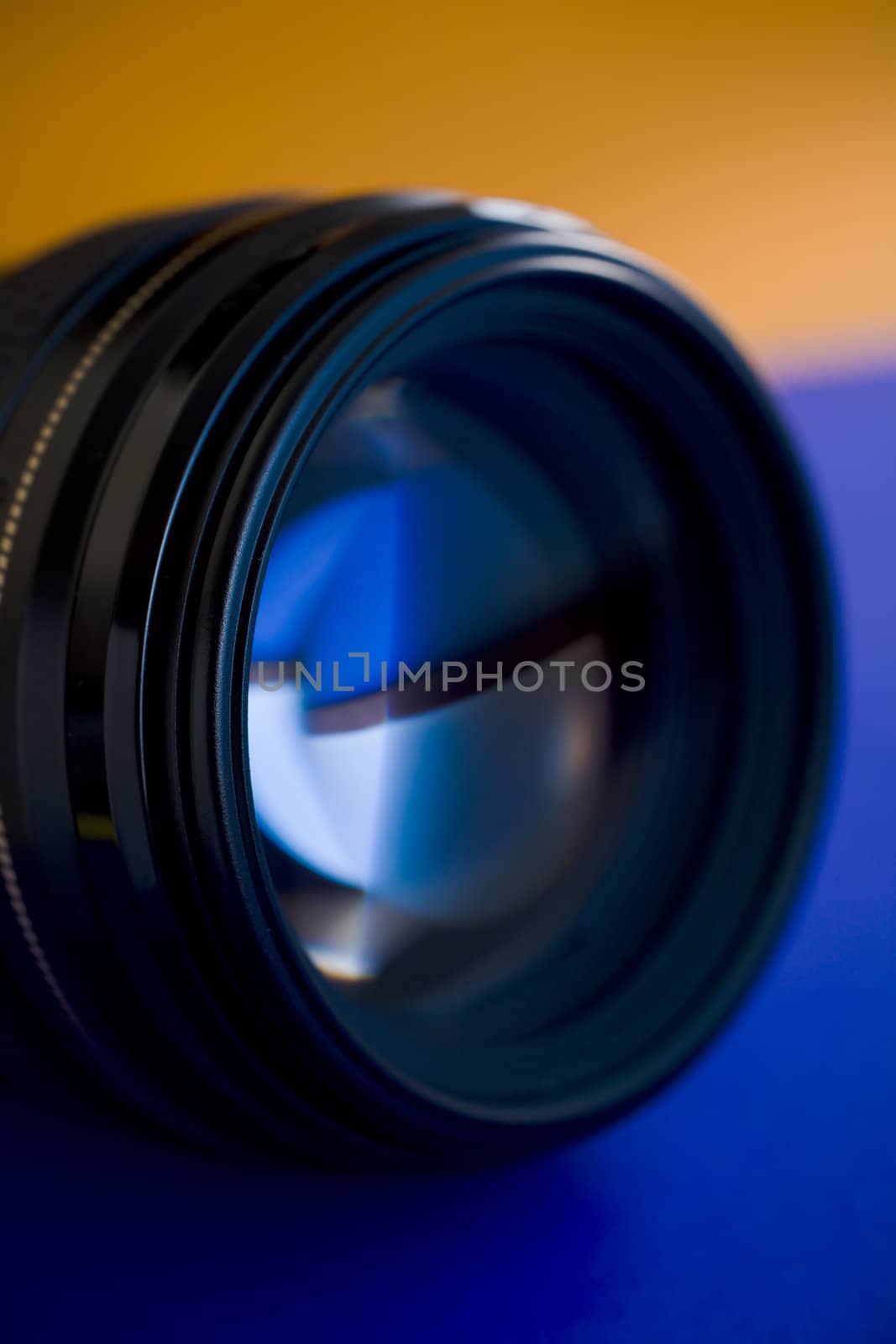 Camera lens close up on blue and orange background