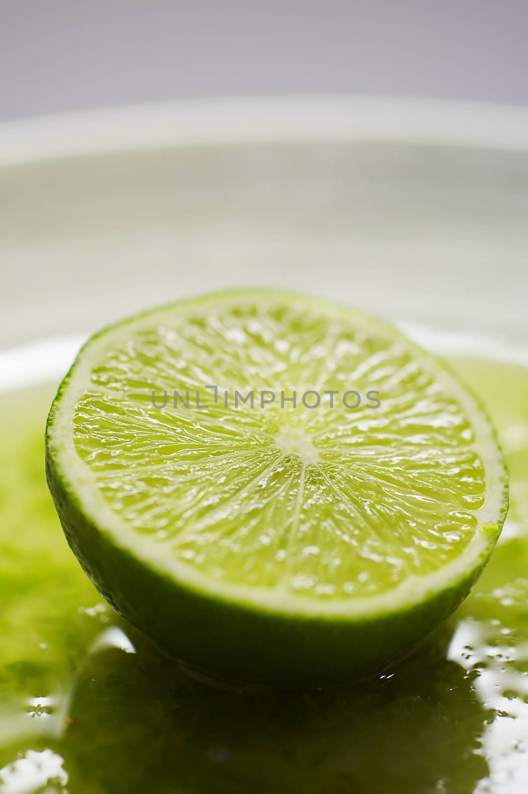 Green lime on the plate with juice